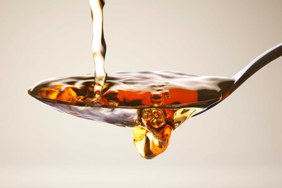 Apple Cider Vinegar being poured on a spoon