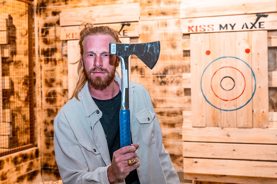 A man holding an axe near his face