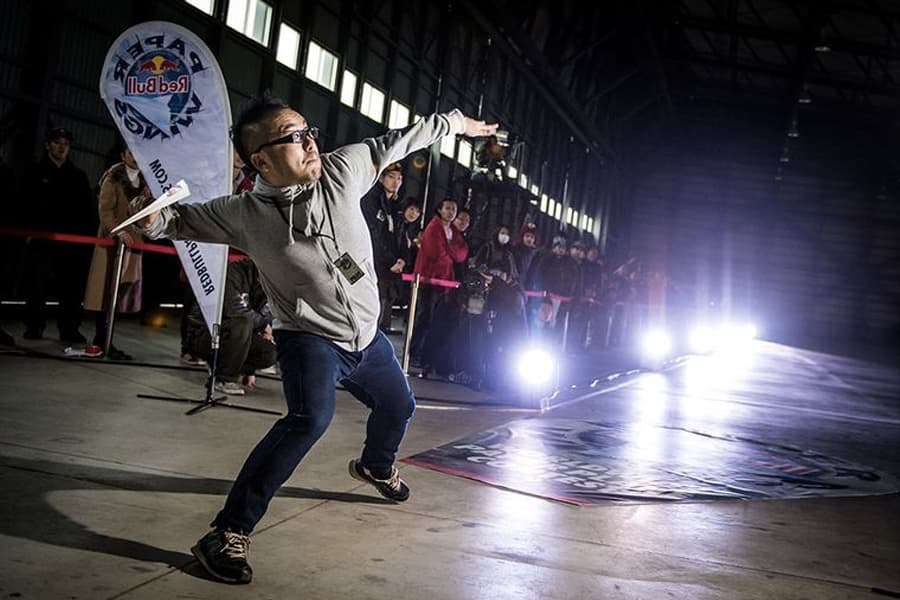 A man about to throw a paper aeroplane with force