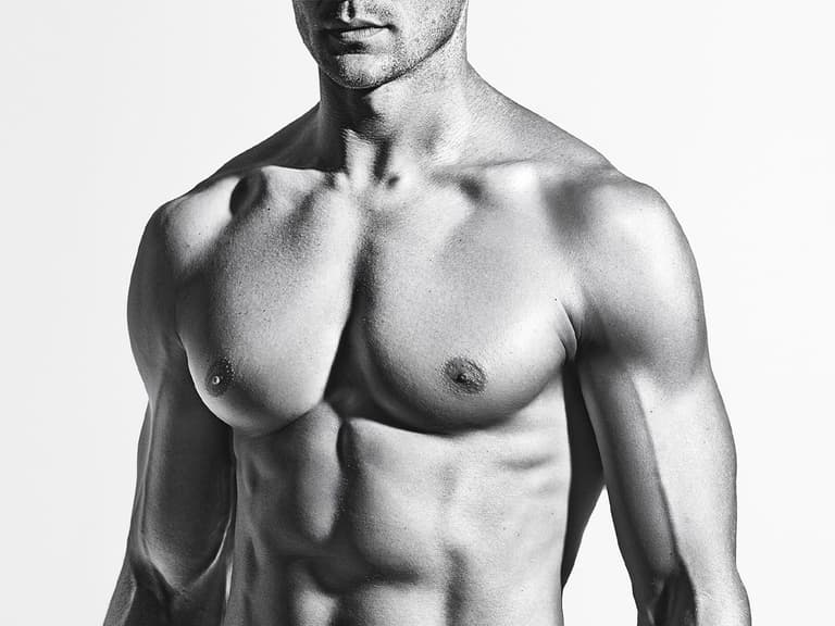 Greyscale close up of a muscular man’s bare chest