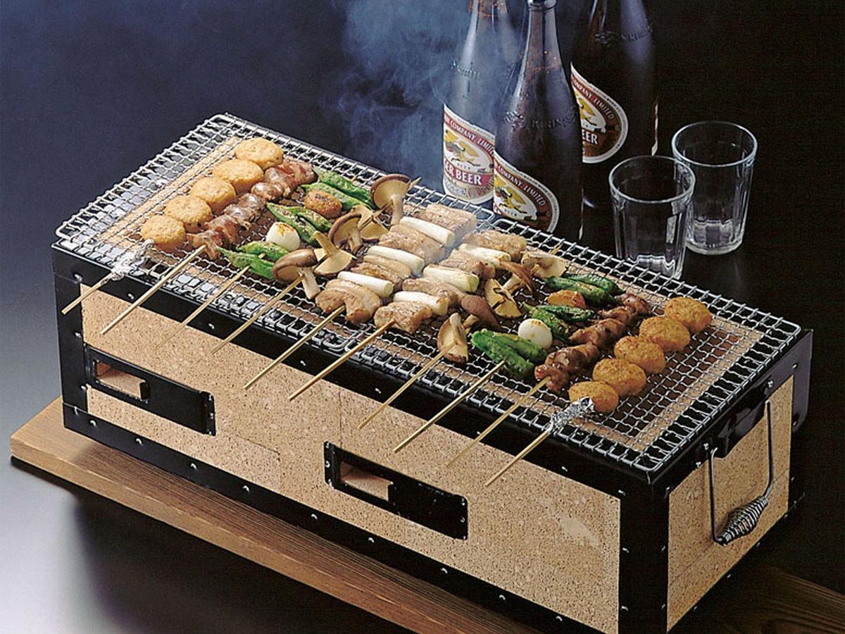 Food skewers on a Hibachi grill and bottles of beer