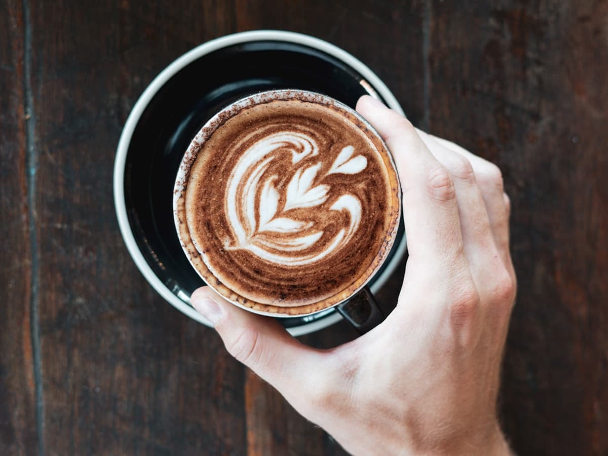 hand holding a cup of latte