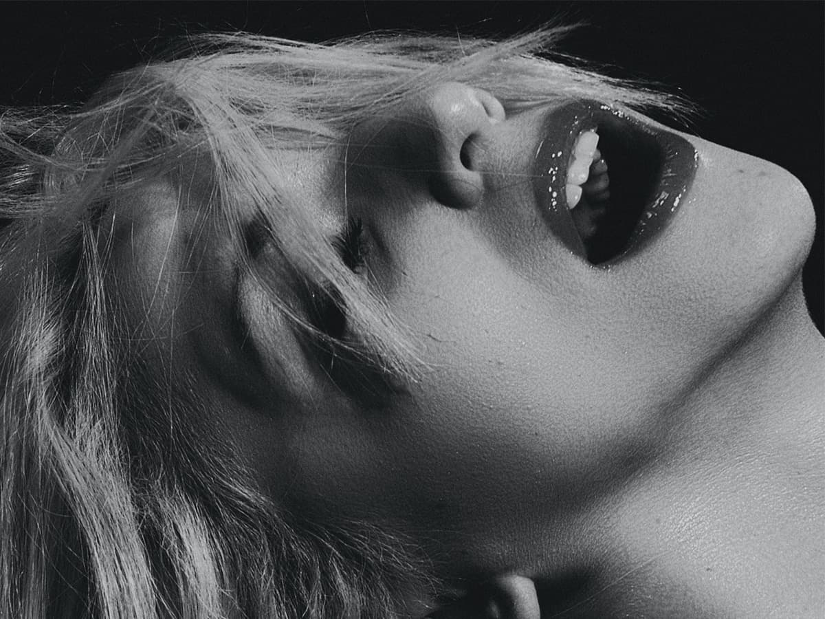 Closeup of a moaning woman's face with her eyes closed