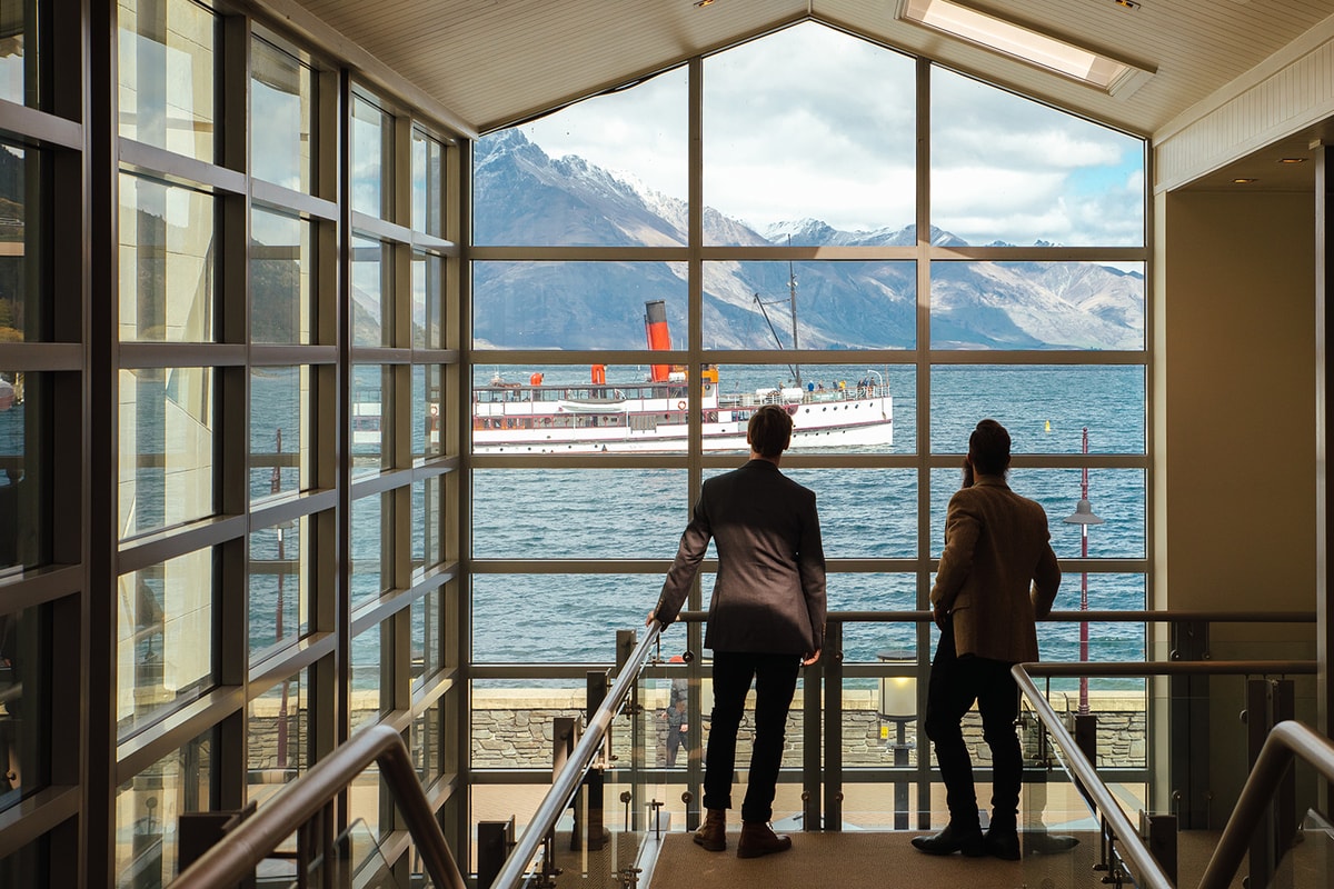 Jimmy and a man looking at a ship through a glass wall