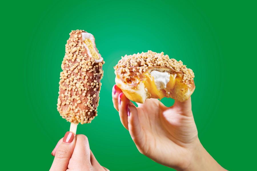 Hands holding Golden Gaytime Krispy Kreme and half-eaten Krispy Cream Golden Gaytime Donut