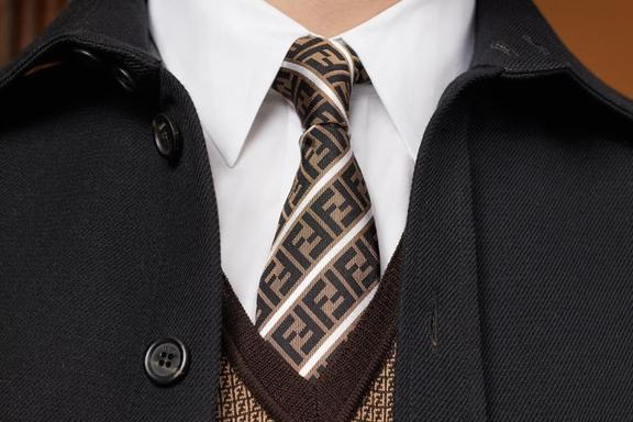 Closeup of a the chest of a man in suit with a Fendi tie