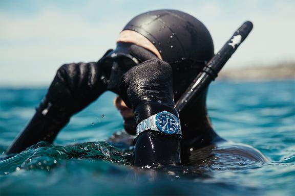 A diver in black wetsuit on surface wearing Glashütte Original watch
