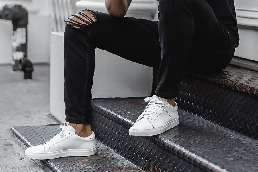 Legs of a model in black jeans and white sneaker