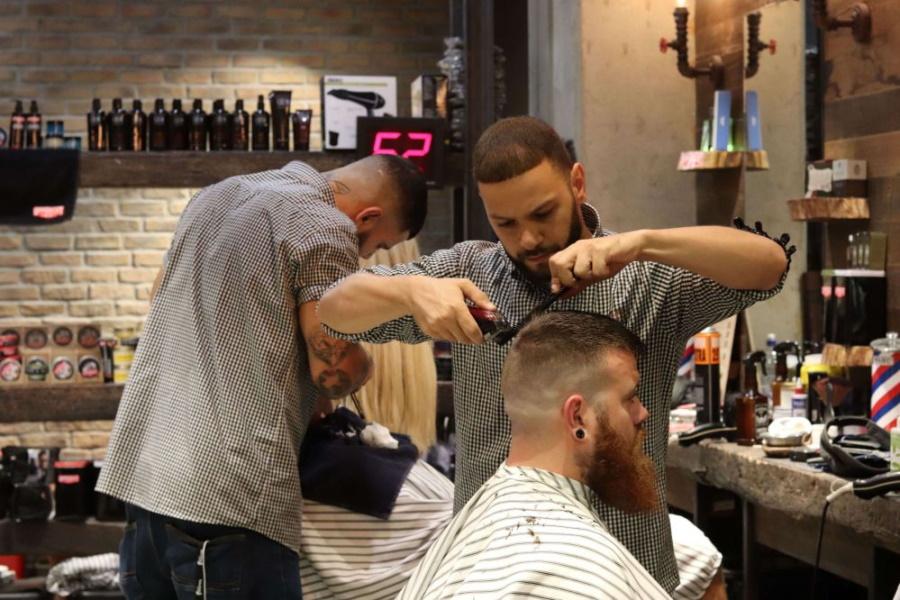 Barbers cutting hair of customers