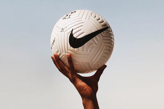 A hand holding a Nike Flight football