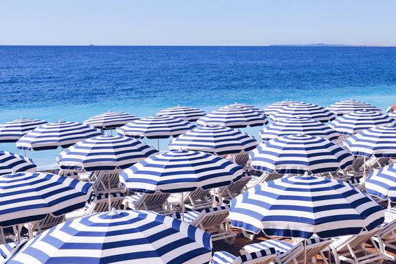 A beach full of umbrellas with chairs under them