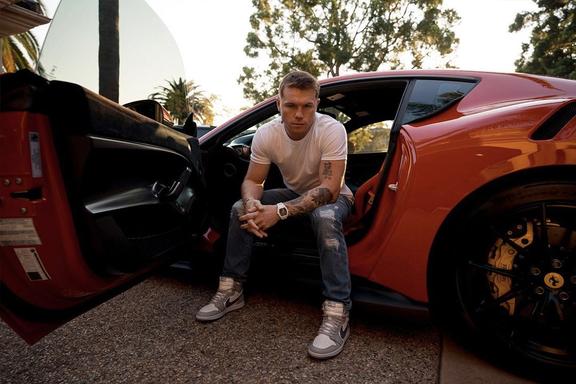 "Cinnamon" Alvarez sitting in a Lamborghini seat with his feet outside