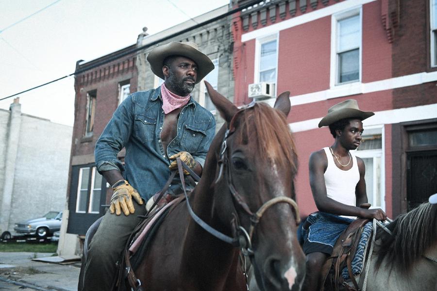 Idris Elba and Caleb McLaughlin riding horses from Concreye Cowboy