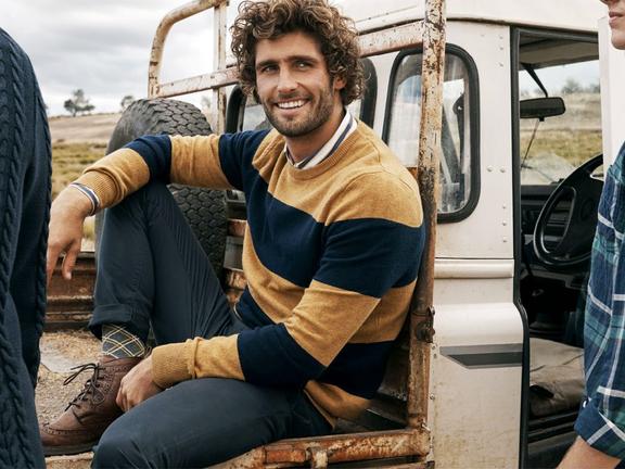 Male model wearing yellow and blue sweater