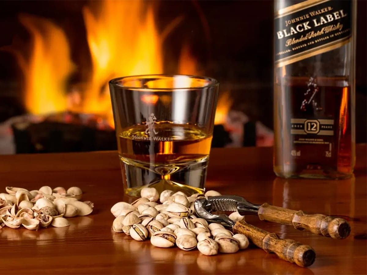 a glass of whisky and a bottle of johnnie walker black label