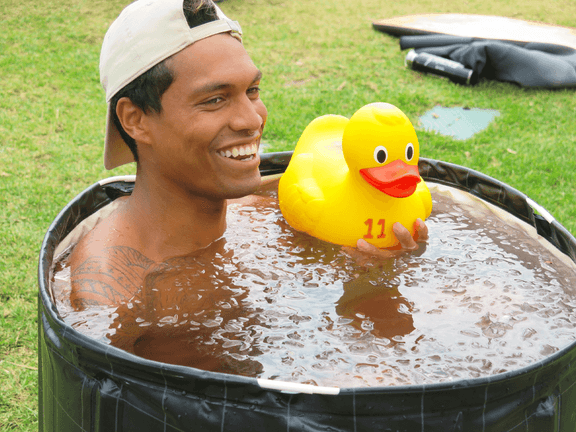 Man in a drum of water with a floating yellow rubber duck