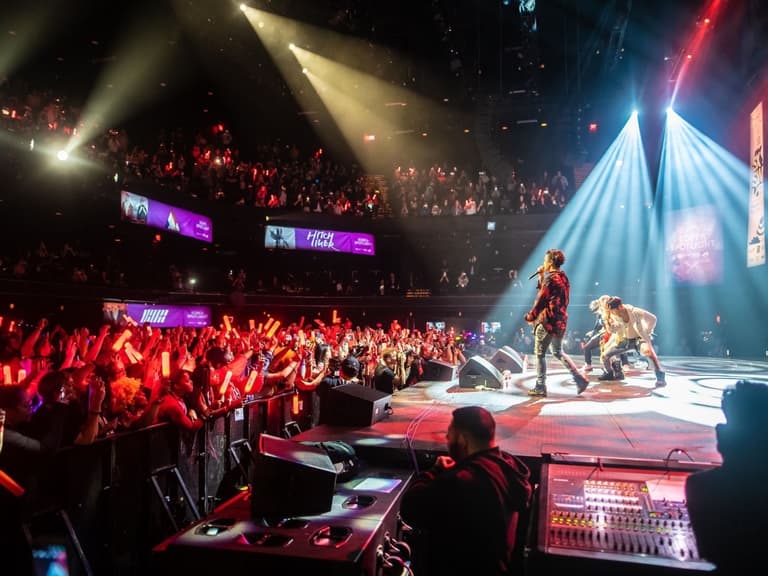 Performers on stage at SXSW Sydney with vibrant lighting and an enthusiastic crowd in a packed venue.