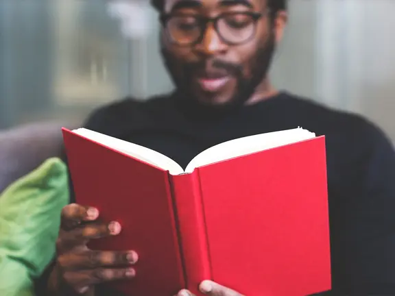 Man laughing at a book he's reading