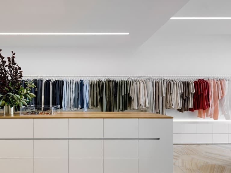 Clothes hanging on racks along a wall