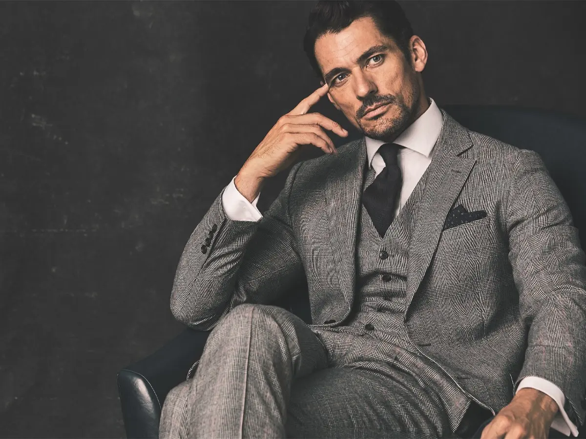 Man in grey suit sitting on a navy leather chair