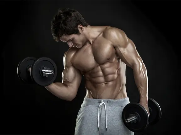 Medium shot of a bodybuilder flexing his right arm while lifting dumbbells with both hands
