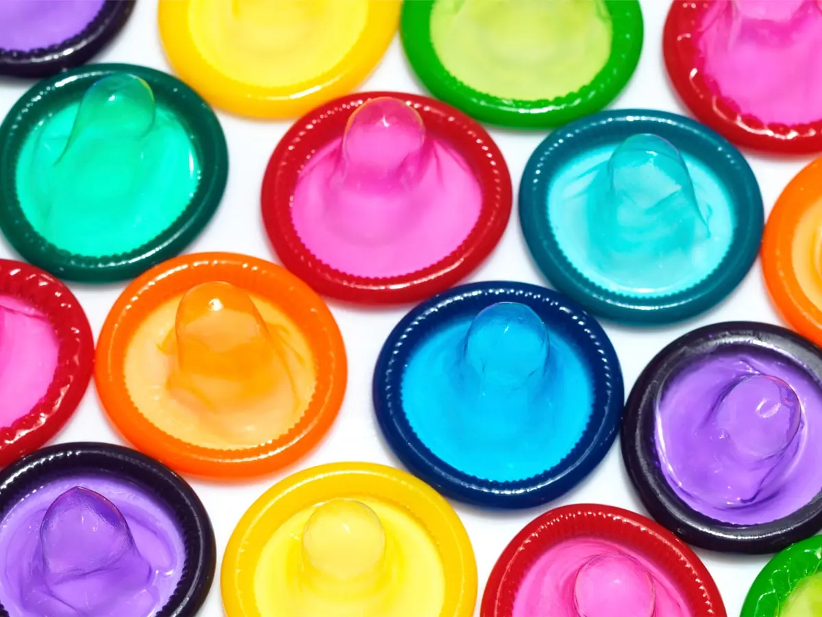 Different colour condoms on a white background