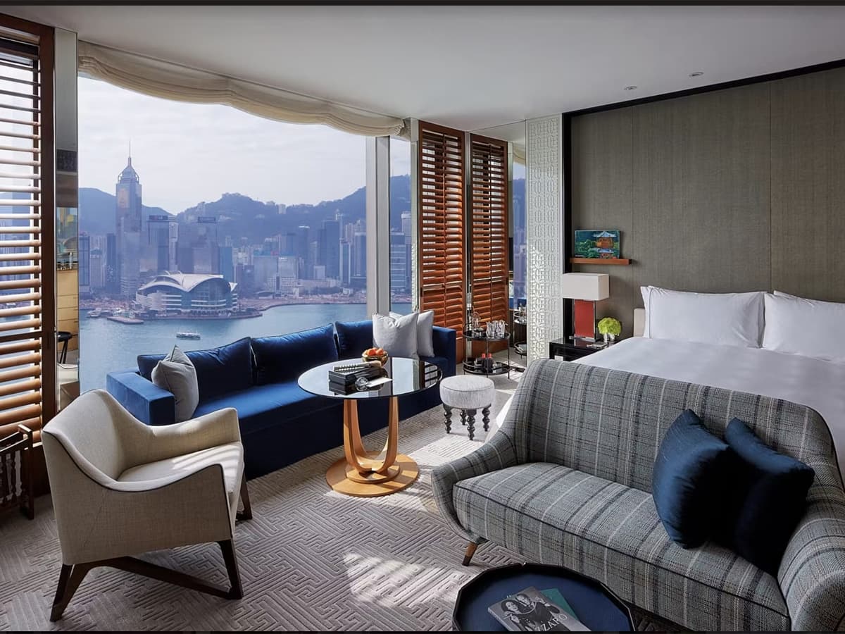 Rosewood Hong Kong hotel room with harbour view, featuring modern furniture, large windows, and elegant decor.