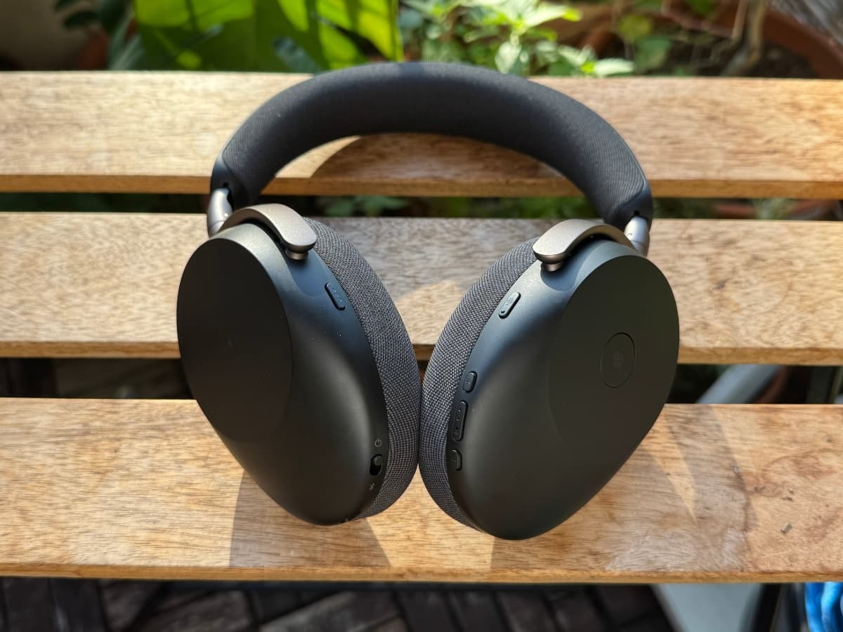Jabra Evolve3 85T headphones in black resting on a wooden bench, with sunlight highlighting their sleek design.