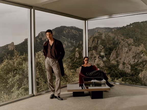 Two male models in Calibre winter tailoring at a glass pavilion in the South of France