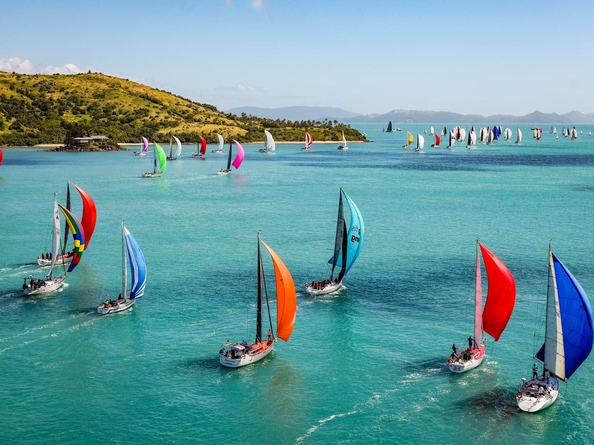 Spinnakers of the Hamilton Island Race Week fleet racing through the Whitsundays