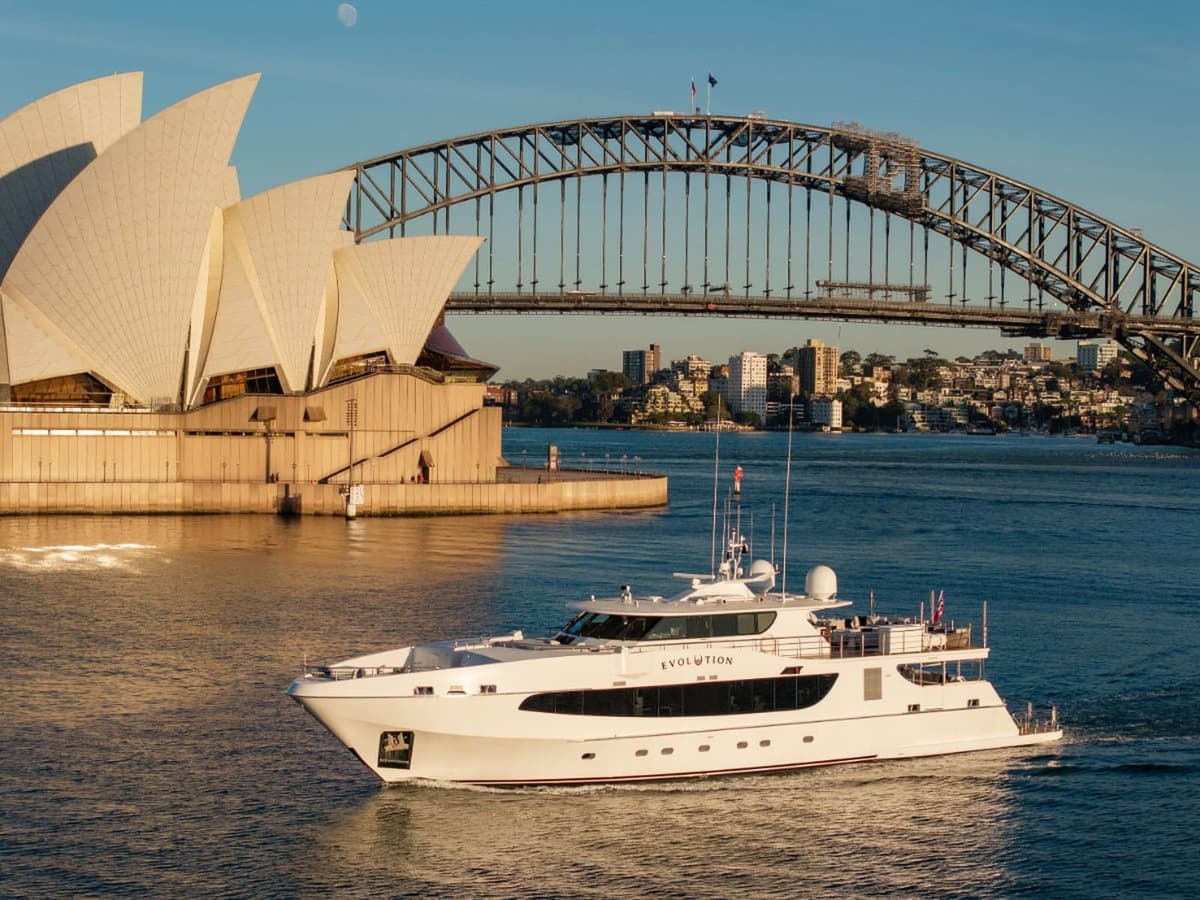 The superyacht Evolution cruising past the Sydney Opera House and Harbour Bridge