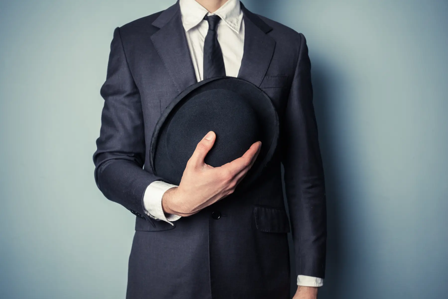 Traje de hombre joven sosteniendo un bombín