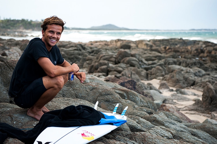 surfer julian wilson sitting on the stone