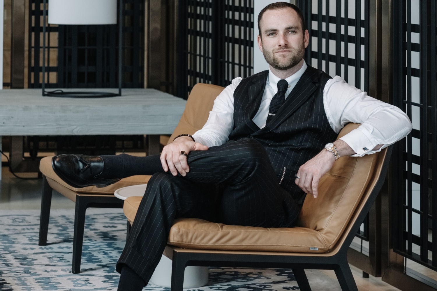 man wearing pinstripe suit in lounge area