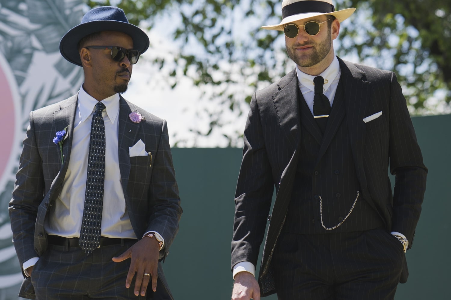 two men wear black stripe suit style