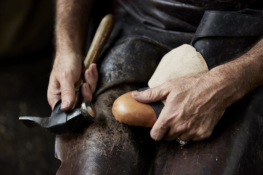 a cobbler repairing the sole of a shoe