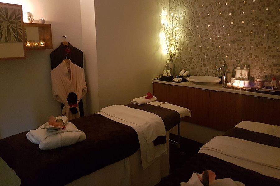 dim massage room with single bed robes hanging