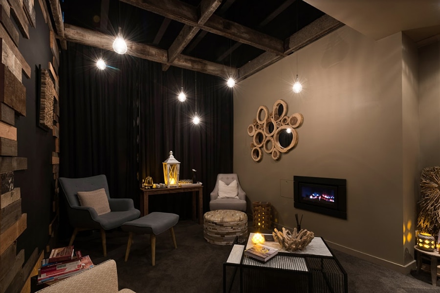 brown lounge room with arm chairs and tv