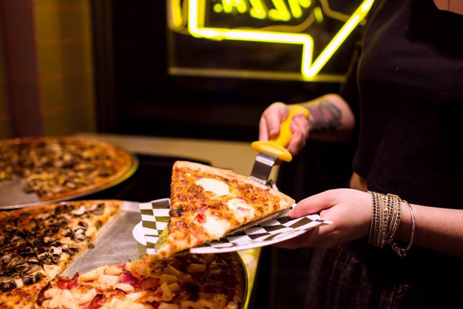 melbourne waiter holding pizza slice