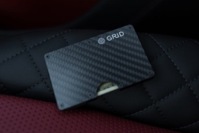 A hand putting Grid wallet in pant pocket