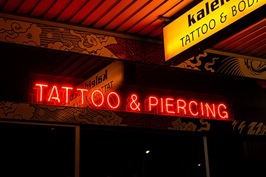 kaleidoscope red neon tattoo and piercing sign