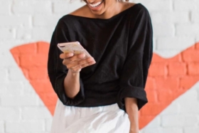 A woman laughing with a phone in her hand