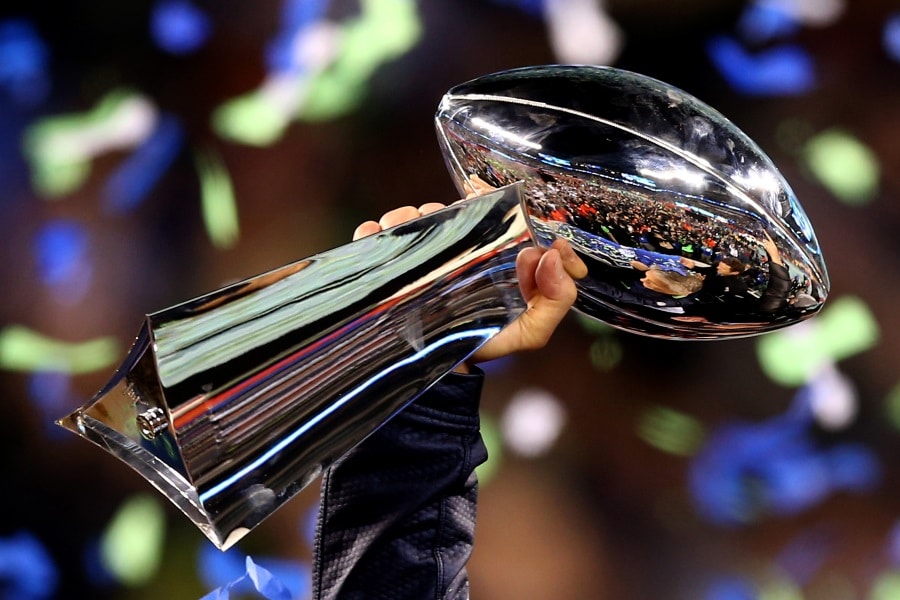 A hand holding Super Bowl trophy