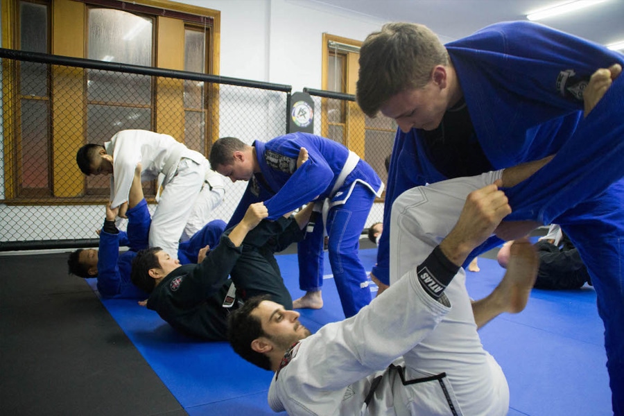 men practicing jiu jitsu on floor