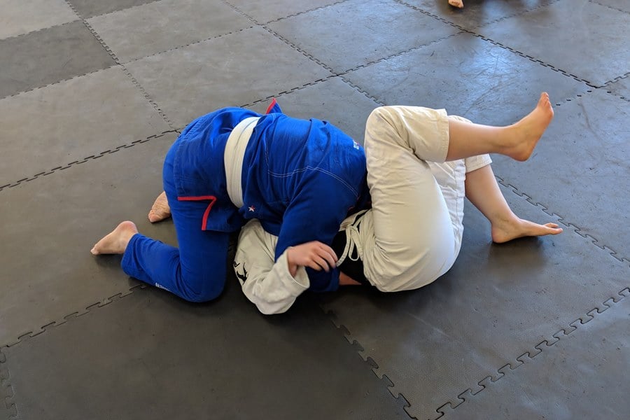 men on floor doing jiu jitsu