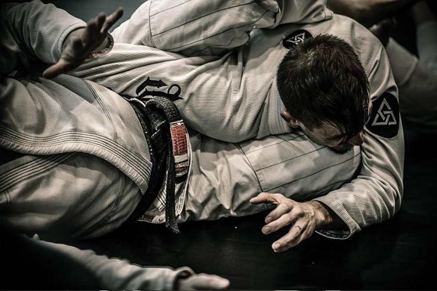 men fighting jiu jitsu