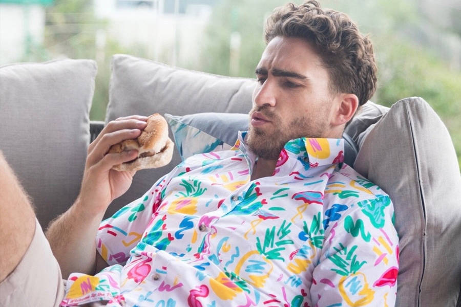 Man in YP thread Hawaiian shirt holding burger