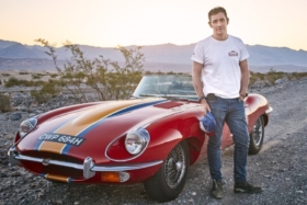 Nick English standing next to his red convertible racer