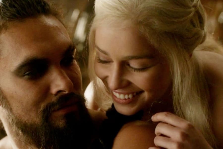 Closeup of Khaleesi with her head on shoulder of Drogo from behind
