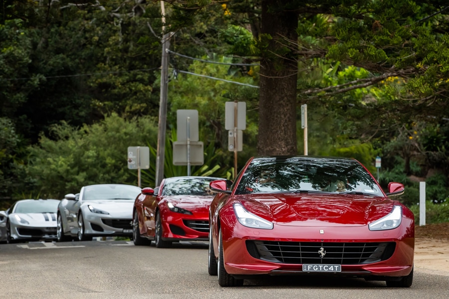 Red Portofino Ferrari on road in line